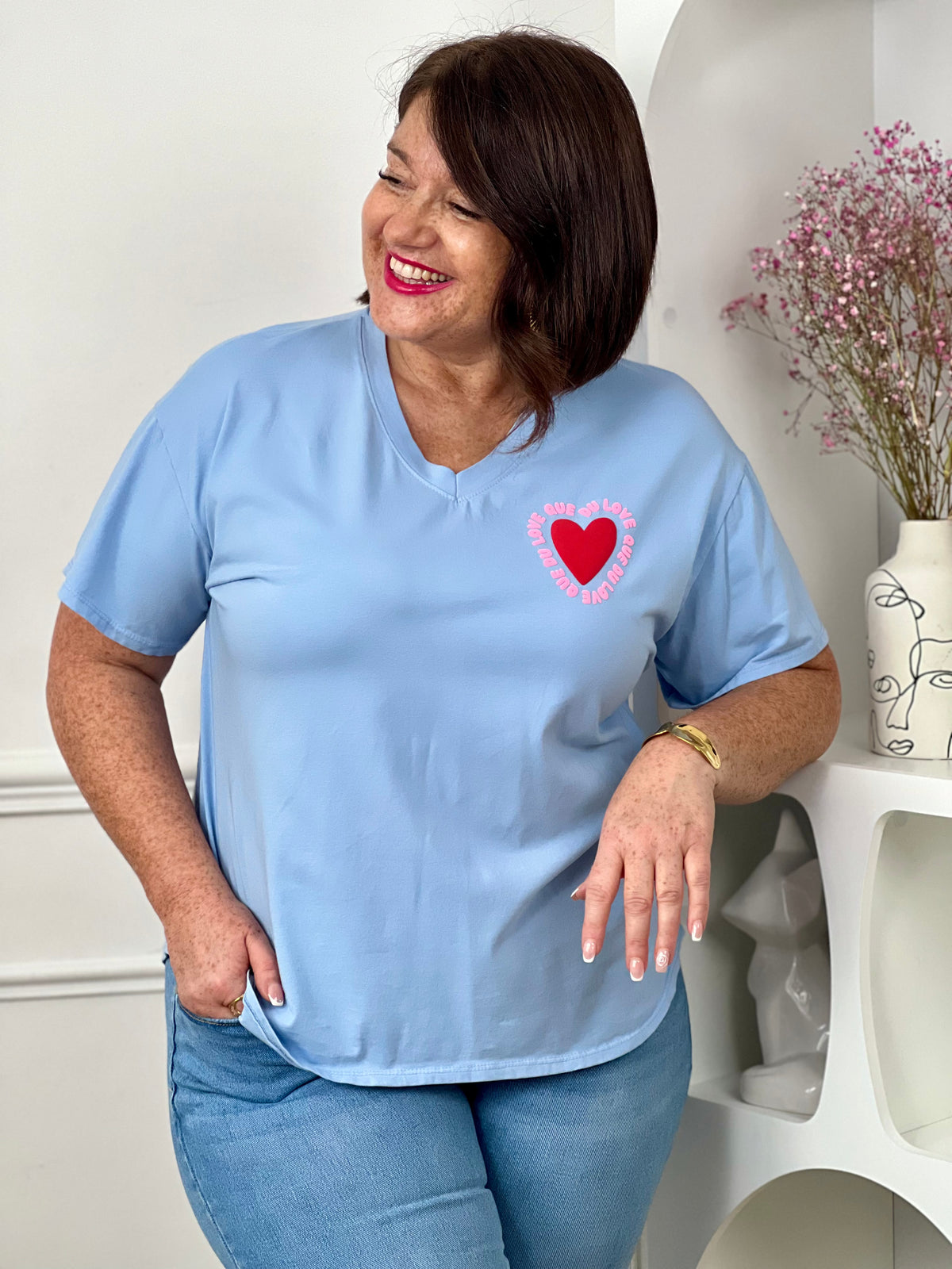 Tee-shirt bleu ciel avec inscription "Que du love" à l’avant et au dos, accompagné d’un cœur pour une touche tendance et positive. Doté de manches courtes et d’un col V, il allie confort et style au quotidien. Ses nuances de bleu, rose et rouge apportent une note fraîche et féminine.