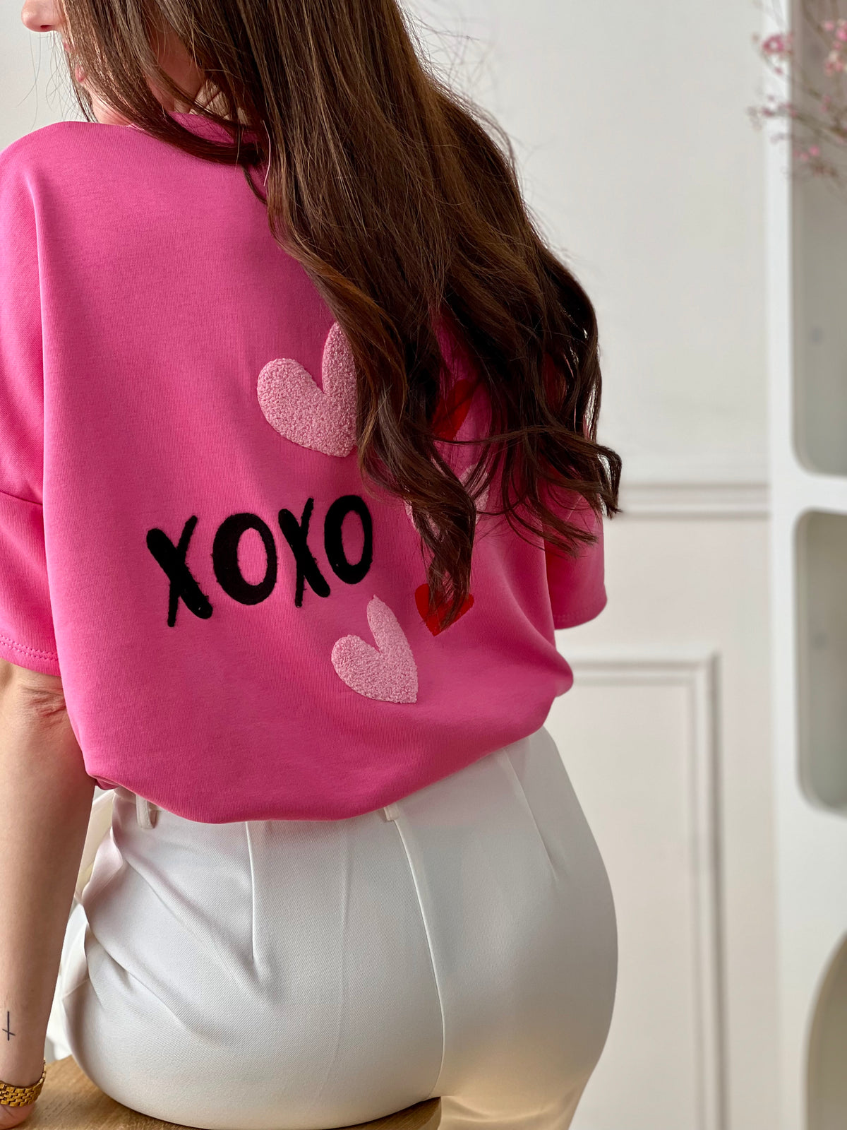 Ce tee-shirt épais rose est un indispensable au style à la fois confortable et tendance. Son inscription « xoxo » apporte une touche fun et moderne, tandis que le cœur en relief au dos ajoute un détail original et plein de charme. Facile à porter, il dynamise instantanément vos looks du quotidien.