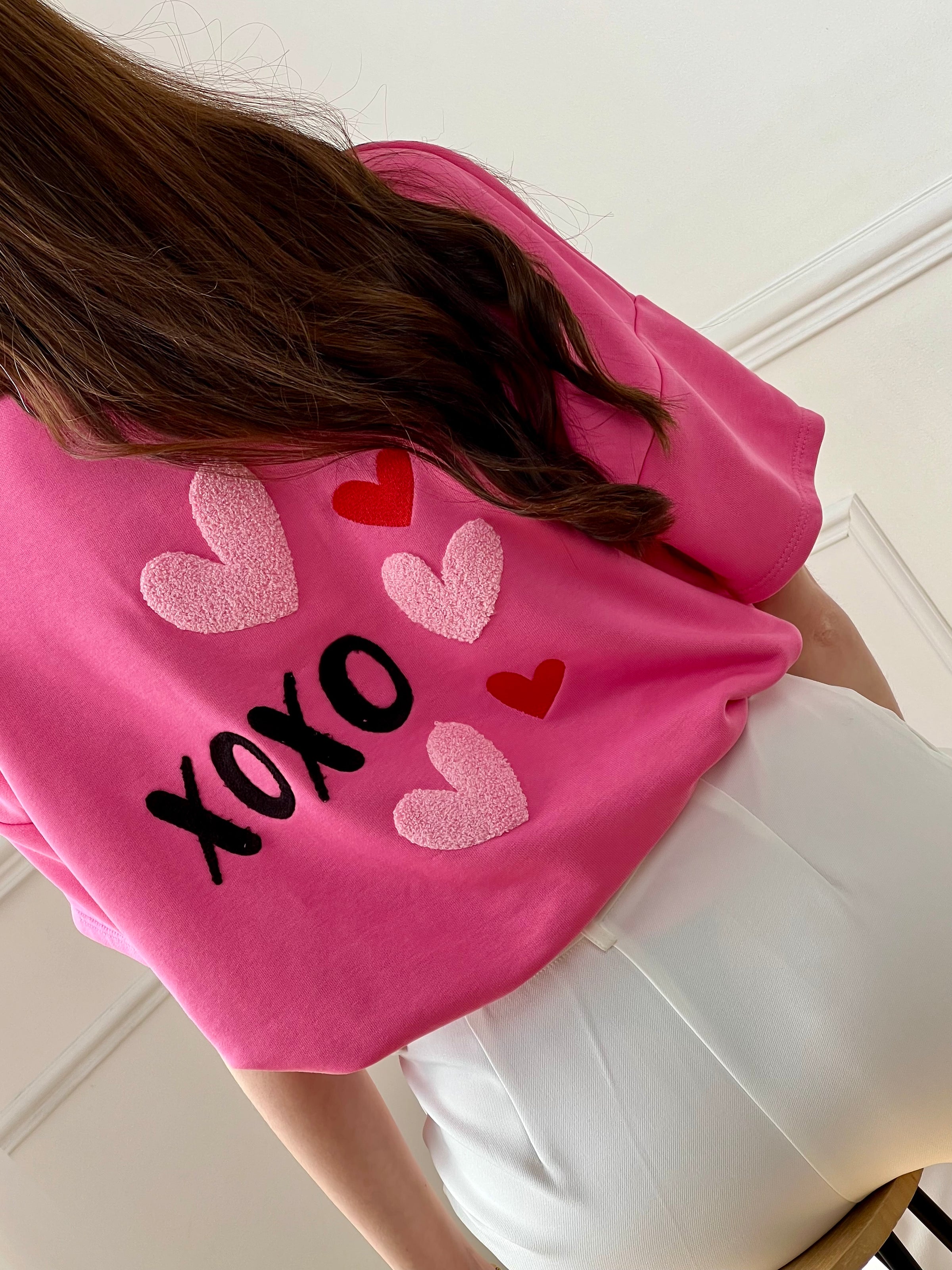 Ce tee-shirt épais rose est un indispensable au style à la fois confortable et tendance. Son inscription « xoxo » apporte une touche fun et moderne, tandis que le cœur en relief au dos ajoute un détail original et plein de charme. Facile à porter, il dynamise instantanément vos looks du quotidien.