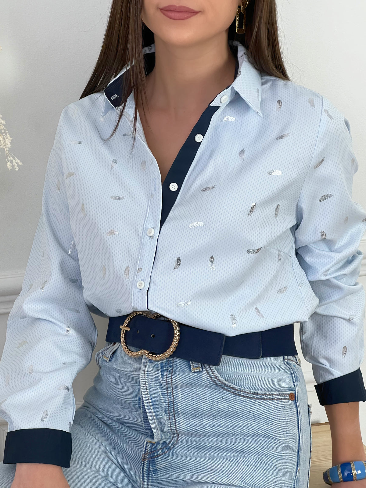 CHEMISE BLEUE A DETAILS ARGENTES FEMME Chemise manches longues Motifs plumes argentées Col chemise Boutons écrus sur la longueur et aux poignets Couleurs : bleu clair et bleu marine sur la longueur des boutons, aux poignets et haut du dos interne Composition : 55% polyester 45% Coton Lavage à la main obligatoire Fabriqué en R.P.C